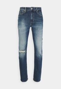 Jeans in denim blu con una vestibilità rilassata. Presentano un ginocchio strappato, variazioni di colore sbiadite, design classico a cinque tasche e accessori metallici.