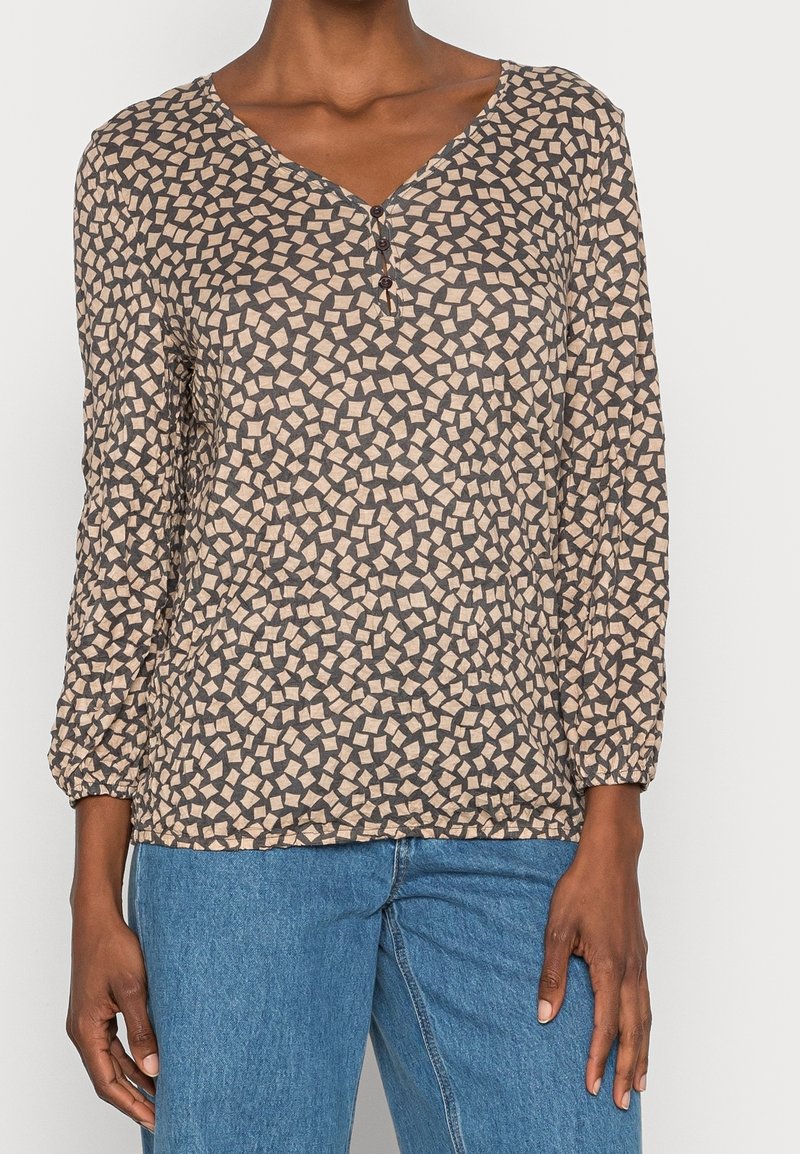 Langærmet beige bluse med geometrisk mønster i mørkebrun, V-hals med knaplukning og elastiske manchetter.