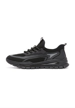 Chaussure de sport noire avec tige en maille, semelle en caoutchouc et détails raffinés. Elle est dotée de lacets et d'un design profilé bas pour plus de confort.
