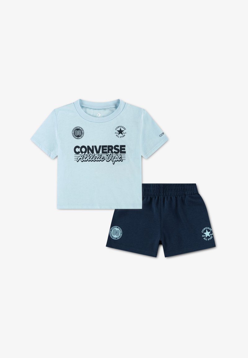 T-shirt en coton bleu clair avec impression noire "Converse Athletic Depts.", associé à un short bleu foncé avec logos latéraux et ceinture élastique.