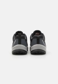 Gray athletic shoes featuring a textured fabric upper, padded collar, pull tab, and a durable rubber outsole.