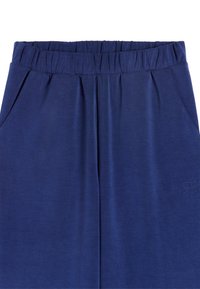 Granatowe jogger pants z elastycznym pasem, wykonane z miękkiego materiału, z dwiema bocznymi kieszeniami i subtelnym haftem logo w tonacji na nodze.