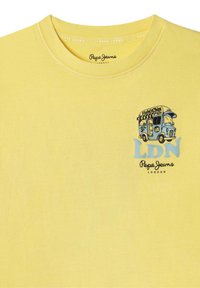 Geltona medvilninė marškinė, kuriuose atspausdinta maisto sunkvežimio grafika, mėlyna spalva "LDN" ir juoda spalva "Pepe Jeans London" po grafika.