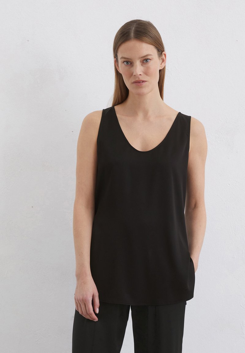 Débardeur noir sans manches avec un décolleté en V profond, fabriqué dans un tissu lisse et léger. Présente une coupe ample et des poches latérales discrètes.