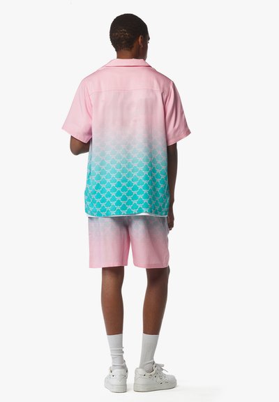 Ensemble t-shirt à manches courtes et shorts en dégradé rose et turquoise, avec un motif de petites écailles subtil. Fabriqué à partir d'un tissu léger.