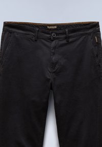 Chinos neri in cotone con zip, tasche frontali e cuciture arancioni a contrasto sulla vita, con etichetta del marchio sul retro.