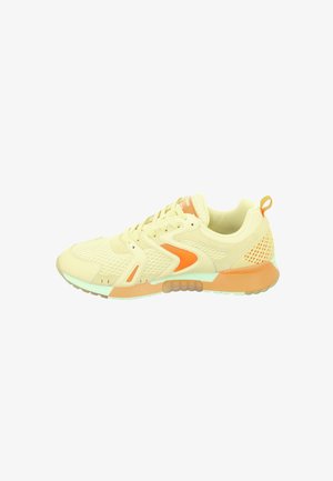 Light yellow athletic shoe with orange accents, mesh panels, and textured rubber sole. Features lace-up front and rear pull tab.