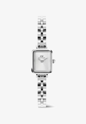 Strieborné hodinky s obdĺžnikovým čelom a prepojeným kovovým remienkom, minimalistický ciferník a logo "DW Daniel Wellington" pod 12. hodinou.