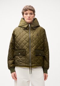 Quilted olivgrüne Jacke mit Kapuze, silbernem Reißverschluss, zwei vorderen Taschen, gerippten Bündchen und Kordelzugsaum. Weicher, strukturierter Stoff.
