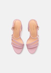 Lila högklackade sandaler med tre breda remmar och spänne. Slät lädertextur med nude-färgad sula och minimalistisk design.