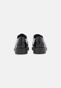Schwarze Lacklederschuhe mit glatter Oberfläche, runder Zehenpartie und einer robusten schwarzen Gummisohle. Verfügt über detaillierte Nähte entlang der Seiten.