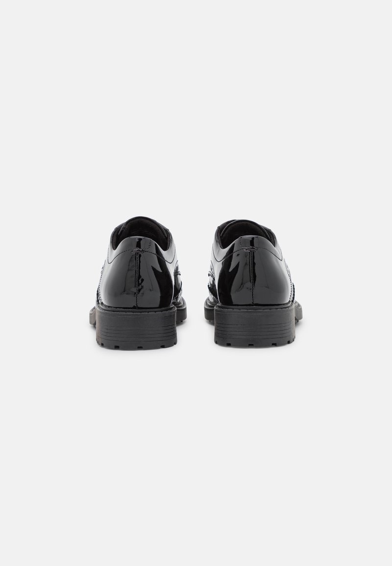 Chaussures en cuir verni noir avec une finition lisse, bout rond et une semelle en caoutchouc noir robuste. Présente une couture détaillée sur les côtés.