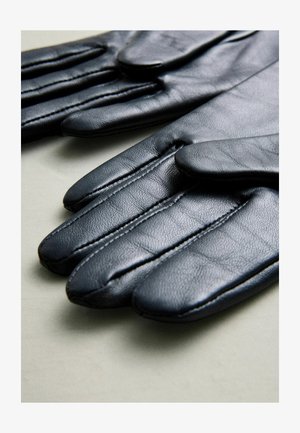 Gants en cuir noir avec une texture lisse, présentant des coutures cousues et un design classique avec des sections pour chaque doigt.