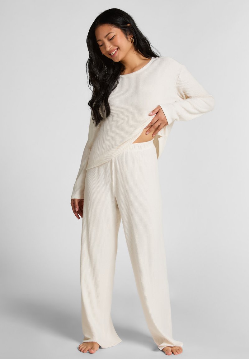 Crème geribbelde loungewear set bestaande uit een langshirt met een losse pasvorm en een elastische tailleband broek met wijde pijpen.