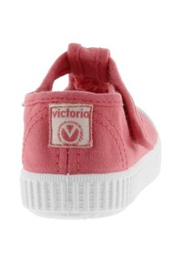 Sneaker in tela rosa con suola in gomma bianca, punta rotonda e linguetta sul tallone. Presenta un'etichetta con il marchio sul retro. Texture morbida e design semplice.