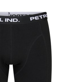 Boxerii pentru bărbați, de culoare neagră, din bumbac, cu un tiv alb pe care este inscripționat textul "PETROL IND.", textură netedă și croiul ajustat.