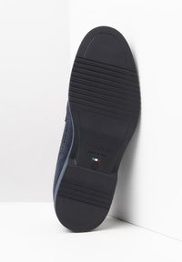 Semelle de chaussure marine présentant une texture striée, un talon prononcé et le logo "NeroGiardini". Conçue en caoutchouc durable, fabriquée en Italie.