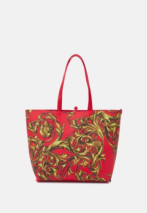 Sac fourre-tout rouge avec un design baroque floral ornemental doré et deux bretelles, sur fond blanc.