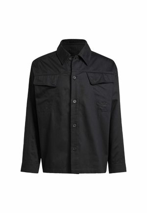 Black button-up shirt made from smooth fabric, featuring two chest pockets, a collar, and vertical seam detailing on the shoulders.