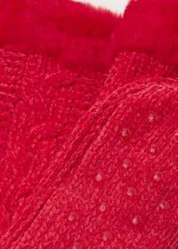 Pantofole in pile rosso con motivo a maglia testurizzata e bordo peloso, con puntini lisci e rialzati per la presa sulla suola.