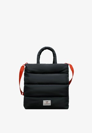 Bolsa de mano negra y acolchada con un diseño estructurado, que presenta un asa superior y una correa de hombro naranja desmontable. Parche de logo notable en la parte frontal.