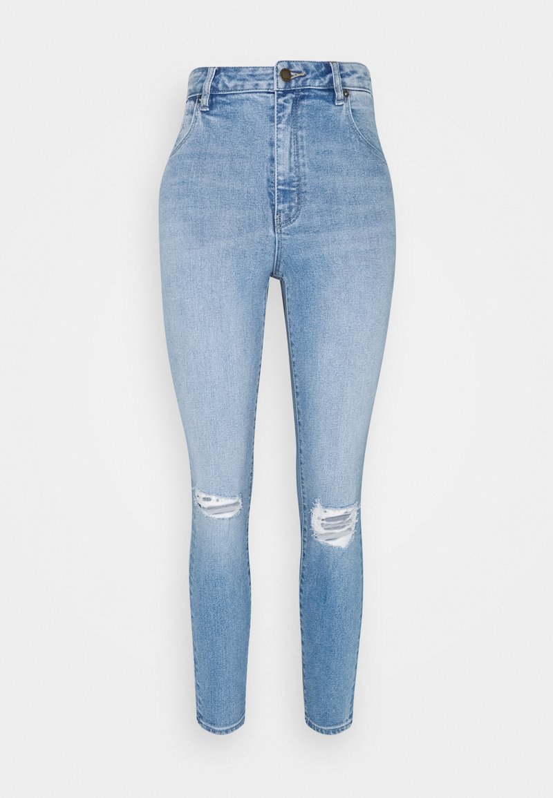 Calças skinny de cintura alta em azul claro, feitas de denim, com dois rasgos nos joelhos e fecho de botão. Textura suave com uma silhueta ajustada.