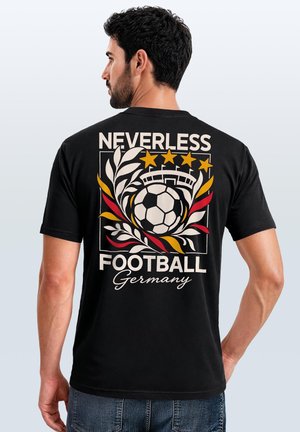 Mann trägt schwarzes T-Shirt mit einem Fußball, Sternen, Blättern und dem Text "NEVERLESS FOOTBALL Germany" auf dem Rücken.