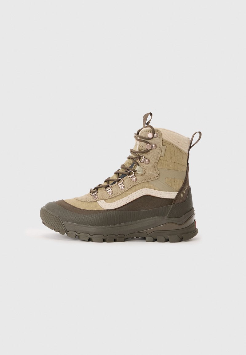 Høykantet turstøvel i olivengrønn og beige. Tekstil overdel med gummisåle, metallhull, forsterket tå og hæltab for enkel påtaking.