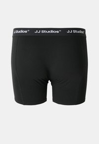 Schwarze dehnbare Boxershorts mit elastischem Bund, der das "JJ Studios"-Logo in Weiß zeigt; glatte Textur, taillierte Passform, Länge bis zur Mitte des Oberschenkels.