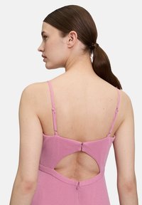 Różowa, bezramionowa sukienka z teksturowanej tkaniny. Posiada detal w postaci dekoltu w kształcie łezki z tyłu oraz regulowane ramiączka z małym zapięciem z tyłu.