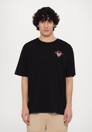 Black cotton t-shirt with short sleeves, features red and black graphic text on the left chest, relaxed fit, smooth texture.