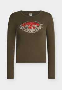 Φλοί πράσινο crop top με μακριά μανίκια και στρογγυλή λαιμόκοψη, με κόκκινο και μπεζ γραφικό "oregon college league" και σχέδιο κερασιού στο στήθος.