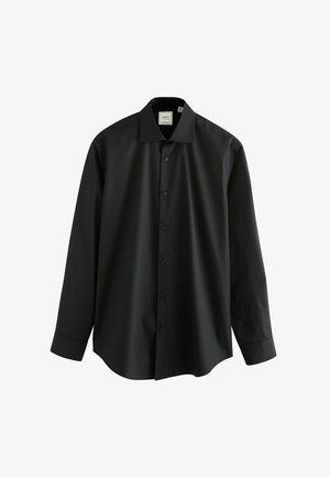 Chemise noire à manches longues en tissu lisse, avec un col classique et une fermeture à boutons à l'avant, au fit ample et décontracté.