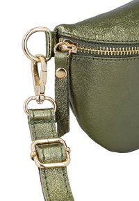 Coin de sac à main en cuir vert métallisé avec fermeture éclair dorée, bouton-pression doré, sangle ajustable et attache en métal avec fermoir mousqueton.