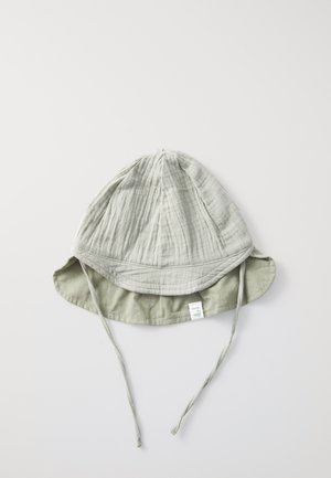Lichtgrijze katoenen bucket hat met een gestructureerde stof, een brede rand en verstelbare kinbanden voor een veilige pasvorm, met een klein zijkoord.