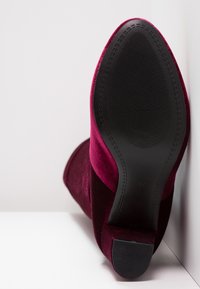 Burgundské sametové kotníkové boty s hladkým povrchem, špičatou špičkou a strukturovanou černou gumovou podrážkou. Velikost 37 označena na podrážce.