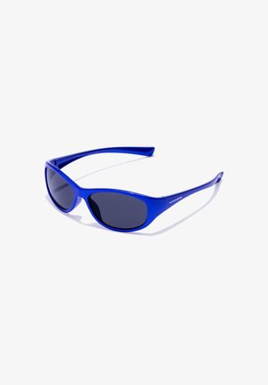 Zilās plastmasas saulesbrilles ar izliekta, gluda dizaina, tumšiem lēcām un plats templis. Pamanāma zīmola identifikācija sānos.