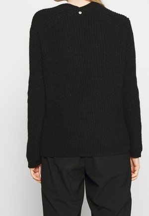 Black knitted sweater with a textured pattern, featuring long sleeves and a back button detail. Simple design with a relaxed fit.