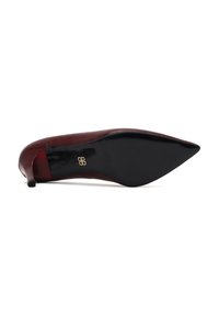 Escarpin à talon aiguille en cuir bordeaux, avec une texture lisse et un dessous noir. Accent logo sur le talon.