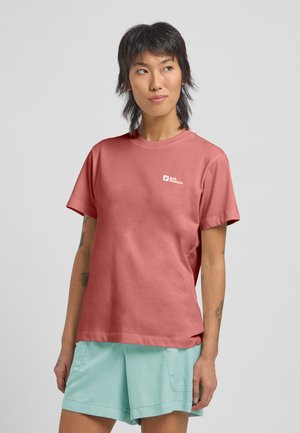 T-shirt en coton rose framboise à manches courtes avec col rond et petit logo blanc sur le côté gauche de la poitrine, associé à un short bleu clair.