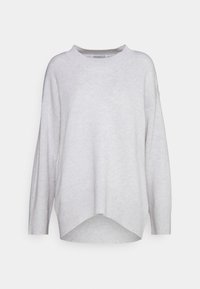 Pull tricot gris clair à coupe carrée, épaules tombantes et ourlet côtelé. Il présente un col rond et des fentes latérales en bas.