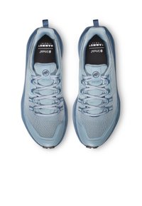 Des chaussures de sport bleu clair présentent un dessus en maille texturée, un embout renforcé et des lacets plats. La semelle est sombre avec un motif de grip.
