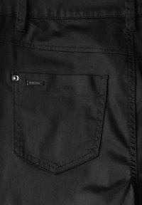 Pantalons en tissu noir avec une poche à rabat dotée de accroches en métal argenté et d'une étiquette de logo discrète. Texture lisse avec des détails de couture soignés.