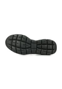 Suela de zapato de goma negra con canales profundos y patrones texturizados para una mejor tracción. Punta redondeada y secciones elevadas para un agarre adicional.