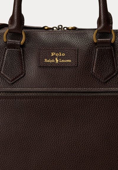 Bolso Polo Ralph Lauren de cuero marrón oscuro texturizado con logo dorado, doble asa, anillas de latón y cierre superior con cremallera visible.