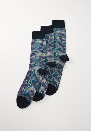 Multicolored socks in a zigzag pattern with navy cuffs and toe. Made of soft fabric, featuring shades of blue, green, and burgundy.