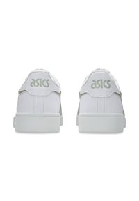 Białe sneakersy z zielonymi akcentami, z górą wykonaną z gładkiej skóry, zaokrąglonym noskiem i wyściełanym kołnierzem. Logo "ASICS" w zielonym kolorze na pięcie.