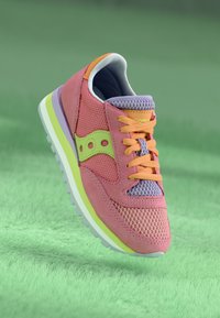 Lyserøde og lavendel sneakers lavet af net- og ruskindsmaterialer, med et orange accent, grøn logo og en hvid sål med en neongrøn stripe.