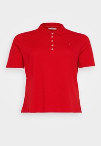 Röd polo skjorta i mjuk bomull, med tre knappslå, korta ärmar och en liten logo broderad på bröstet.