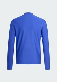 Dlouhý rukáv košile v jednobarevné modré, vyrobená z hladkého materiálu. Disponuje minimalistickým designem s límečkem ve tvaru stojáčku a žádnými viditelnými vzory nebo kovovými prvky.